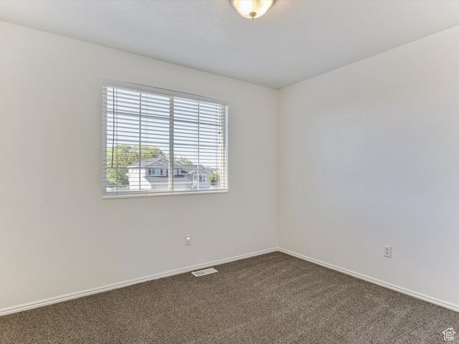 Spare room with dark carpet, visible vents, and baseboards | Image 12