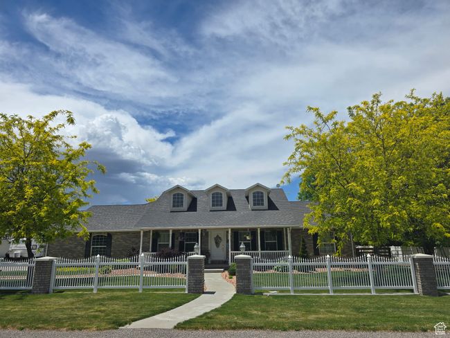 Cape cod home with a shingled roof, brick siding, and covered porch | Image 77