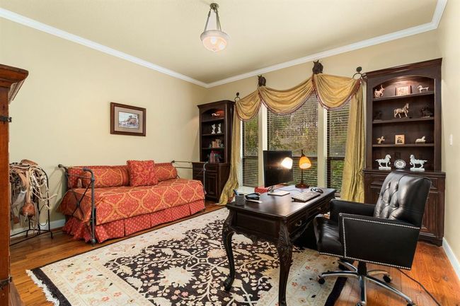 This generously-sized guest bedroom on the first floor serves the homeowners as a second home office. A large picture window provides a glorious view of the grounds. Discreetly hidden in its closet is a Hayman Magna safe to hold any important documents and valuables, securely bolted to the slab. | Image 26