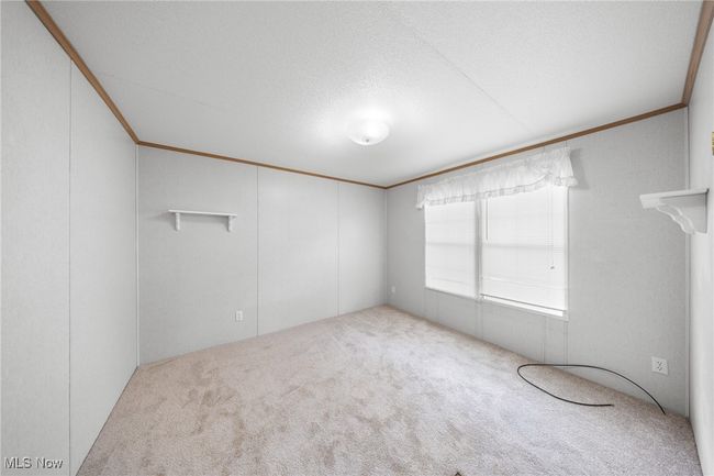 Unfurnished room with carpet flooring, crown molding, and a textured ceiling | Image 12