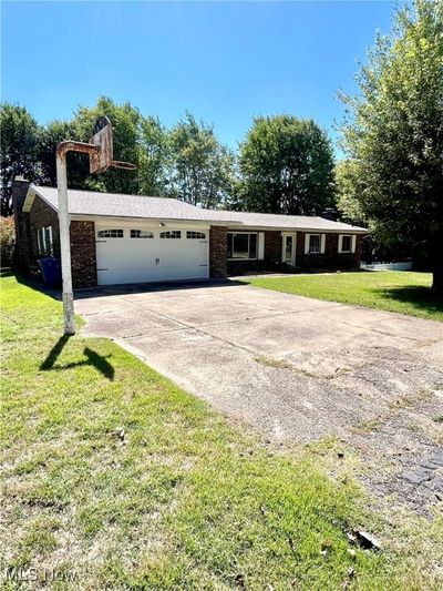 Ranch-style house with a garage and a front lawn | Image 3