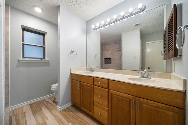 Double-sink vanity with ample storage and updated lighting provides practicality for daily routines. | Image 24