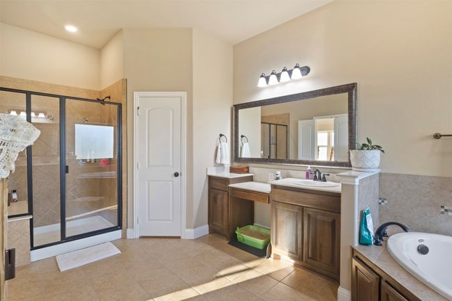 Bathroom featuring a garden tub, tile patterned flooring, vanity, and a stall shower | Image 21