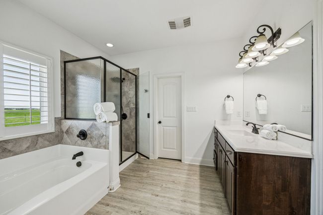 Full bathroom featuring vanity, a garden tub, a shower stall, and wood finished floors | Image 11