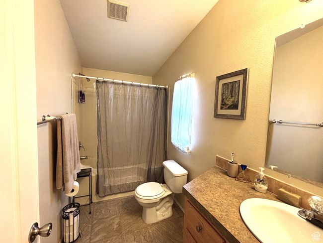 Master bathroom with vanity, vaulted ceiling, toilet, and shower / bath combination with curtain | Image 12
