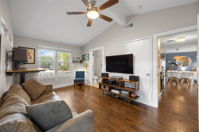 Living room featuring beamed ceiling, ceiling fan, hardwood / wood-style floors, and high vaulted ceiling | Image 17