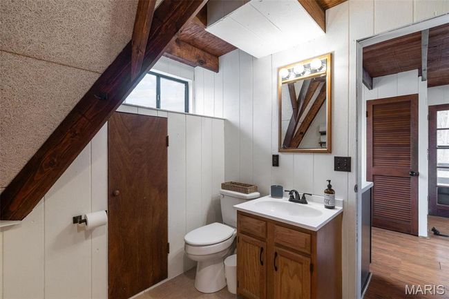 Half bathroom with vanity, beam ceiling, toilet, and wood finished floors | Image 23