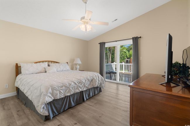 Bedroom featuring light wood finished floors, access to exterior, vaulted ceiling, baseboards, and a ceiling fan | Image 22