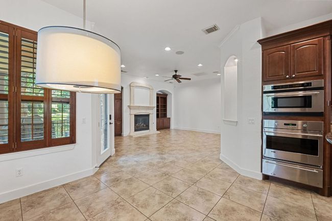 Kitchen featuring a warming drawer, a ceiling fan, light tile patterned floors, recessed lighting, and arched walkways | Image 14