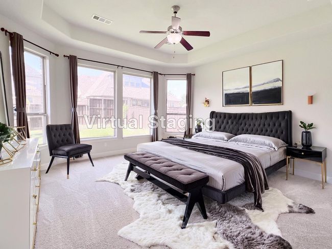 Bedroom with light carpet, a tray ceiling, multiple windows, and ceiling fan | Image 22