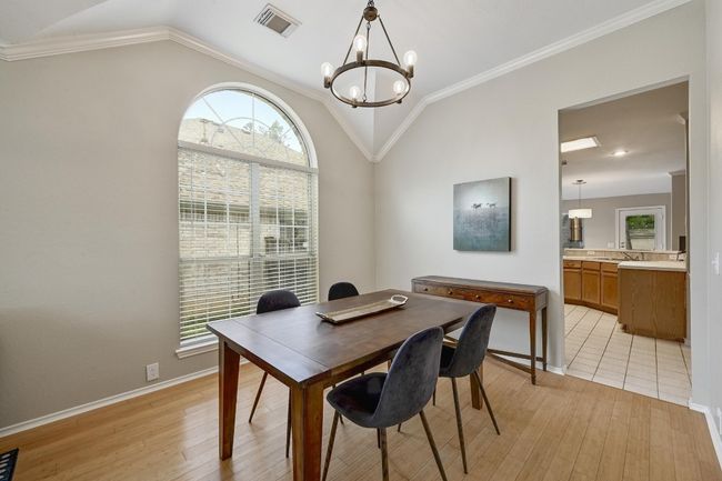 Formal Dining area featuring vaulted ceiling, light wood finished floors, a chandelier, baseboards, and healthy amount of natural light | Image 13