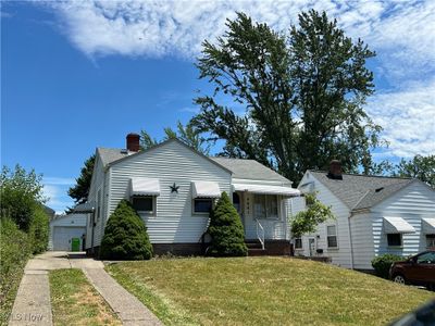 Bungalow with a front yard and a garage | Image 1