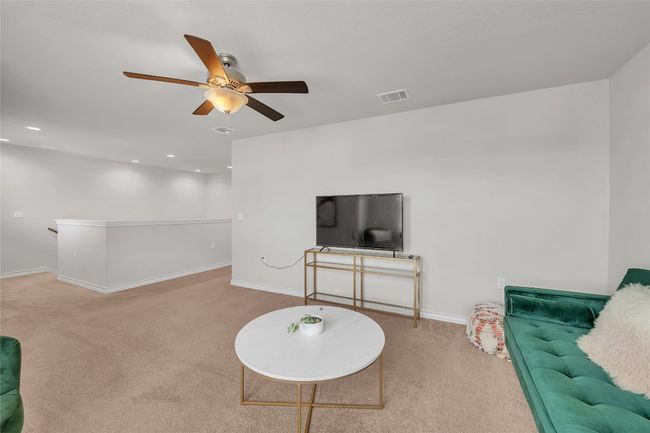 Carpeted living area featuring ceiling fan, baseboards, and recessed lighting | Image 14