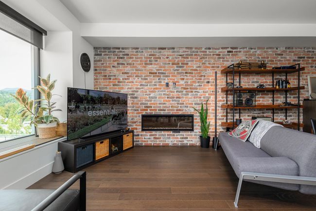 Living area with wood finished floors and a brick fireplace | Image 5