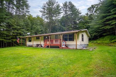 View of front facade with a wooden deck and a front yard | Image 2