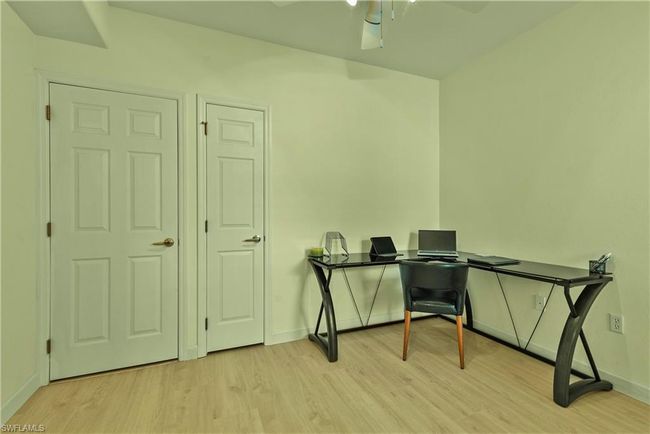 Office space with baseboards, light wood-type flooring, and a ceiling fan | Image 15