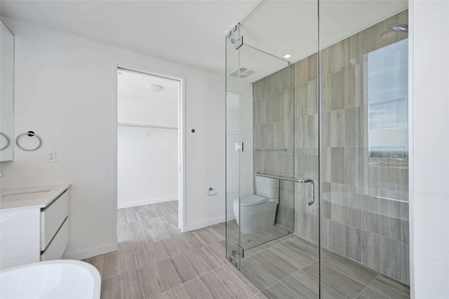 Primary bathroom includes a frameless glass shower, and direct access to a spacious walk-in closet. | Image 9