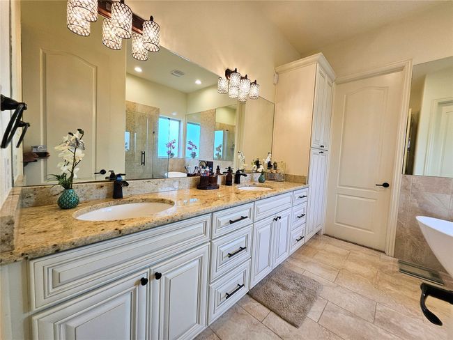 Bathroom with a chandelier, a shower stall, double vanity, and a freestanding bath | Image 24