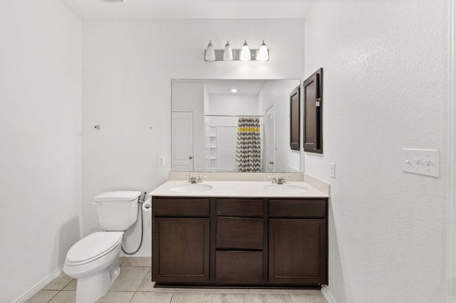 Bathroom featuring double vanity, tile patterned floors, and a shower with curtain | Image 20