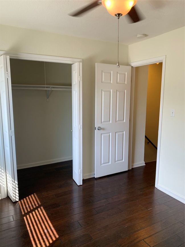 Unfurnished bedroom featuring dark wood-style floors, a closet, baseboards, and a ceiling fan | Image 11