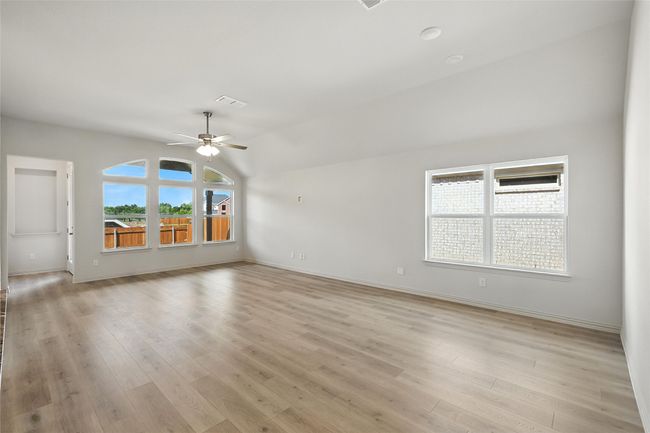 Empty room featuring ceiling fan, light wood finished floors, and lofted ceiling | Image 8
