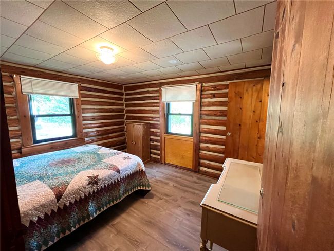 Bedroom with log walls, multiple windows, and wood finished floors | Image 4