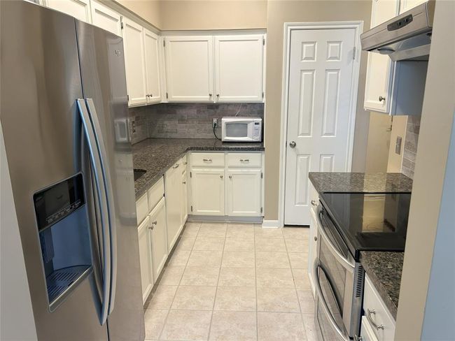 A tastefully updated kitchen with easy to clean tile floors & stainless appliances including the double oven! | Image 18