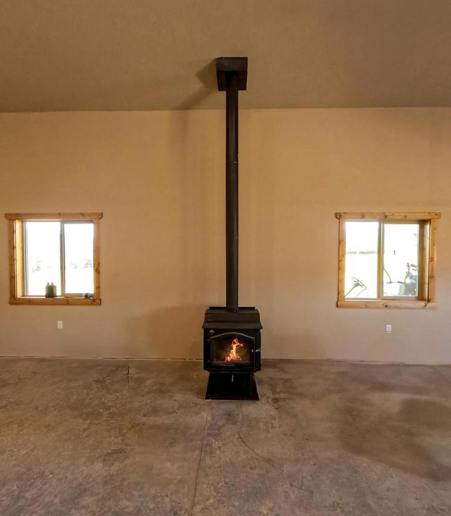 Room details featuring an outdoor fire pit, concrete floors, and a wood stove | Image 29
