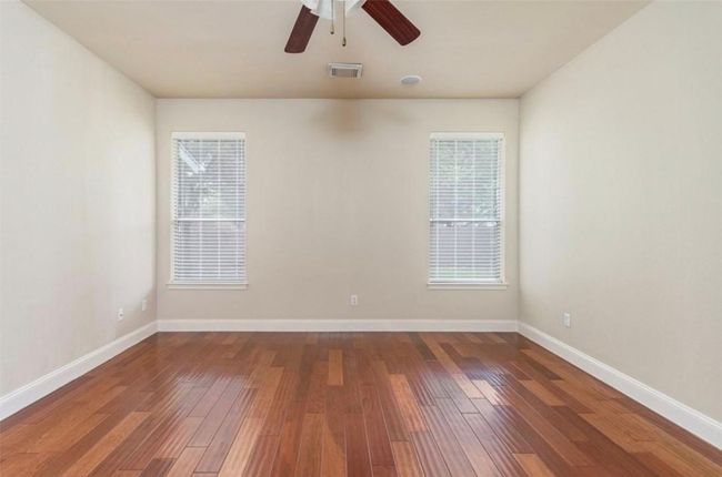 Spare room with baseboards, wood finished floors, and ceiling fan | Image 13