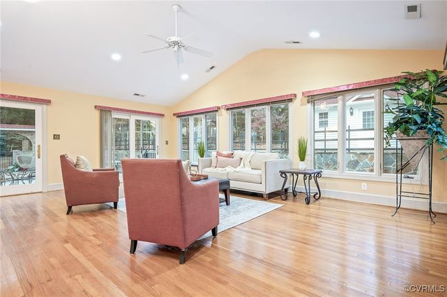 This 29' x 23' Florida room open space with vaulted ceilings, a built-in wet bar, three French doors, and warm hardwoods | Image 22