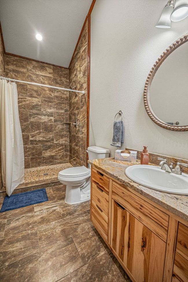 Bathroom with tiled shower, vanity, and toilet | Image 22