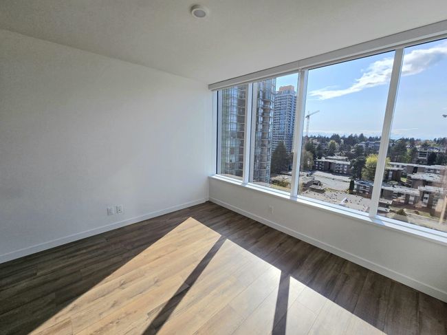 Spare room with baseboards, wood finished floors, a wealth of natural light, and a view of city | Image 15