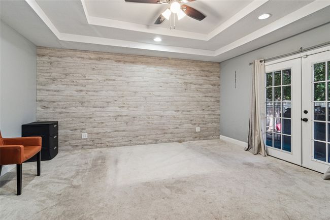 Master Bedroom room with french doors, wood walls, carpet flooring, a raised ceiling, and recessed lighting | Image 13