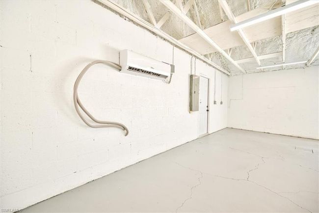 Garage featuring electric panel and a wall unit AC | Image 44