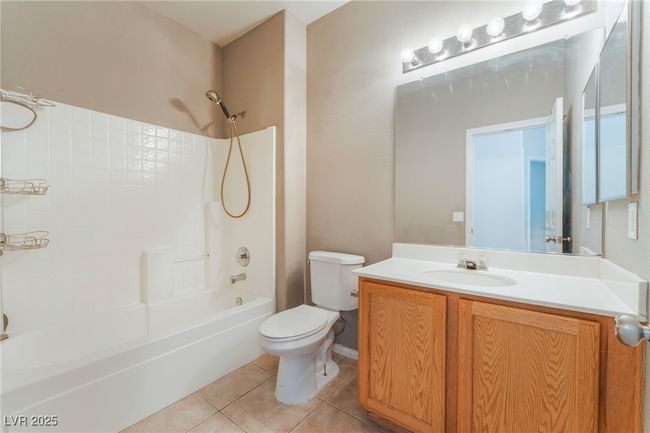 Full bath with toilet, vanity, tile patterned floors, and shower / washtub combination | Image 43
