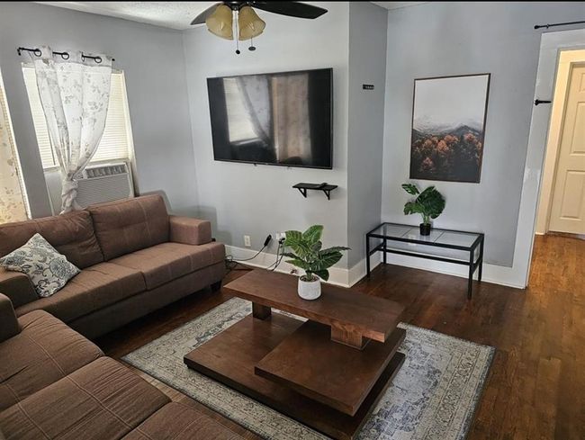 Cozy living room in a charming two-bedroom unit, featuring stylish decor and ample natural light. | Image 8