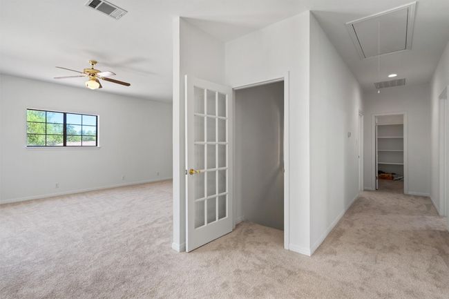 Hallway featuring attic access, visible vents, baseboards, and light carpet | Image 25