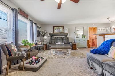 Living room with ceiling fan with notable chandelier and light hardwood / wood-style flooring | Image 3