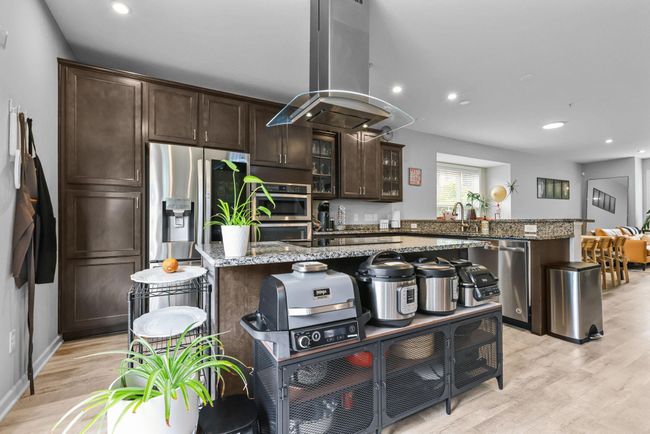 Trendy range hood over the kitchen island. | Image 11