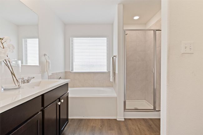Bathroom with wood finished floors, double vanity, a garden tub, and a stall shower | Image 23