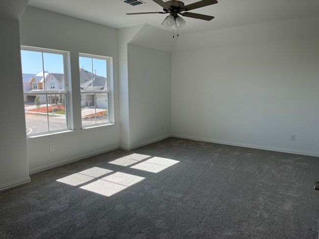 Spare room featuring visible vents, baseboards, a ceiling fan, and carpet flooring | Image 8