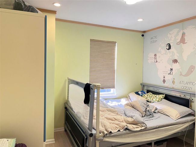 Bedroom featuring baseboards, recessed lighting, ornamental molding, and wood finished floors | Image 9