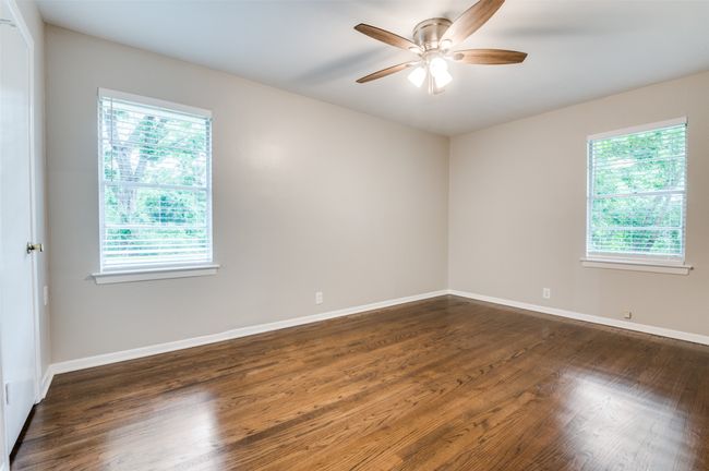 Secondary room with ceiling fan, dark real wood finished floors, and baseboards and lots of natural light. | Image 20