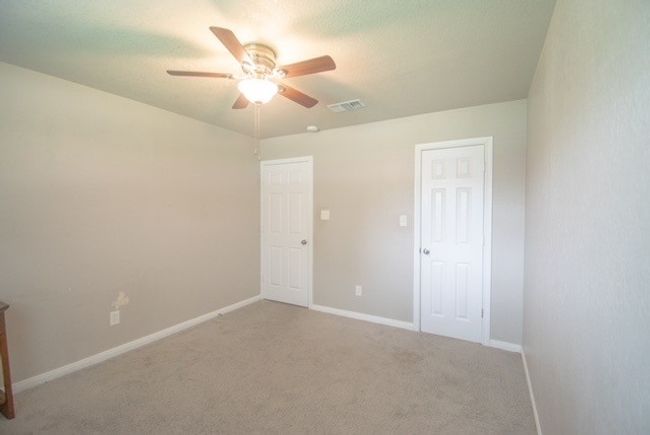 Unfurnished bedroom with light carpet, ceiling fan, and baseboards | Image 9