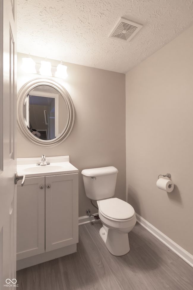 half bath featuring wood finished floors, a textured ceiling, and vanity | Image 5