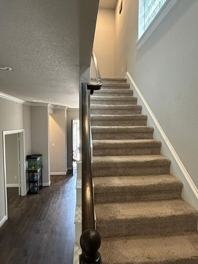 Stairway with hardwood / wood-style flooring, baseboards, crown molding, and a textured ceiling | Image 15