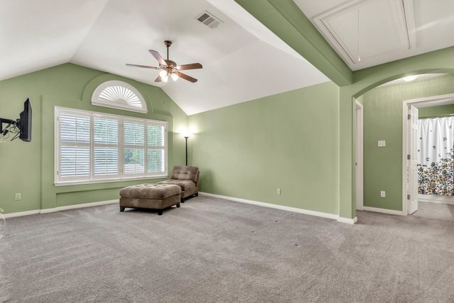 Unfurnished room featuring attic access, visible vents, ceiling fan, and carpet flooring | Image 21