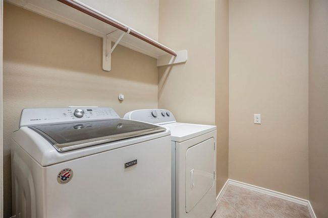 This spacious walk-in laundry room offers convenience and functionality with full-size washer and dryer connections, built-in hanging space, and additional room for shelving or storage. It’s a clean, practical space designed to keep everything organized and out of sight. | Image 28