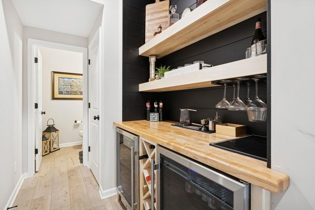 Entry-level custom owner’s bar, conveniently located right off the garage—featuring two mini fridges to keep your drinks perfectly cold as soon as you walk in the door. | Image 16
