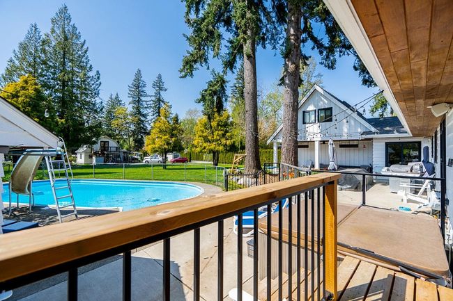 View of swimming pool with a lawn, a patio, and a fenced in pool | Image 14